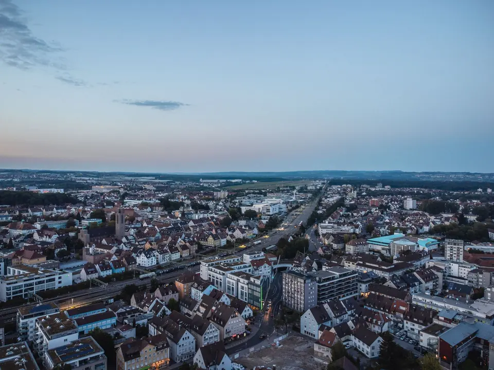 Malersiche Luftaufnahme von Friedrichshafen, Deutschland in der Dämmerung, die die Architektur der Stadt zeigt.